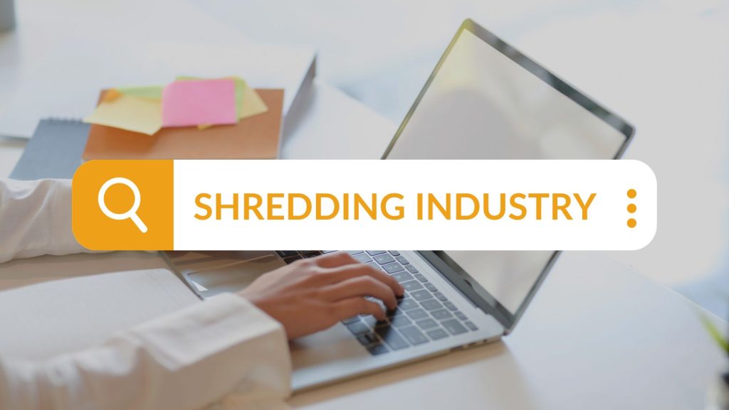 A person typing on a laptop with the words shredding industry.